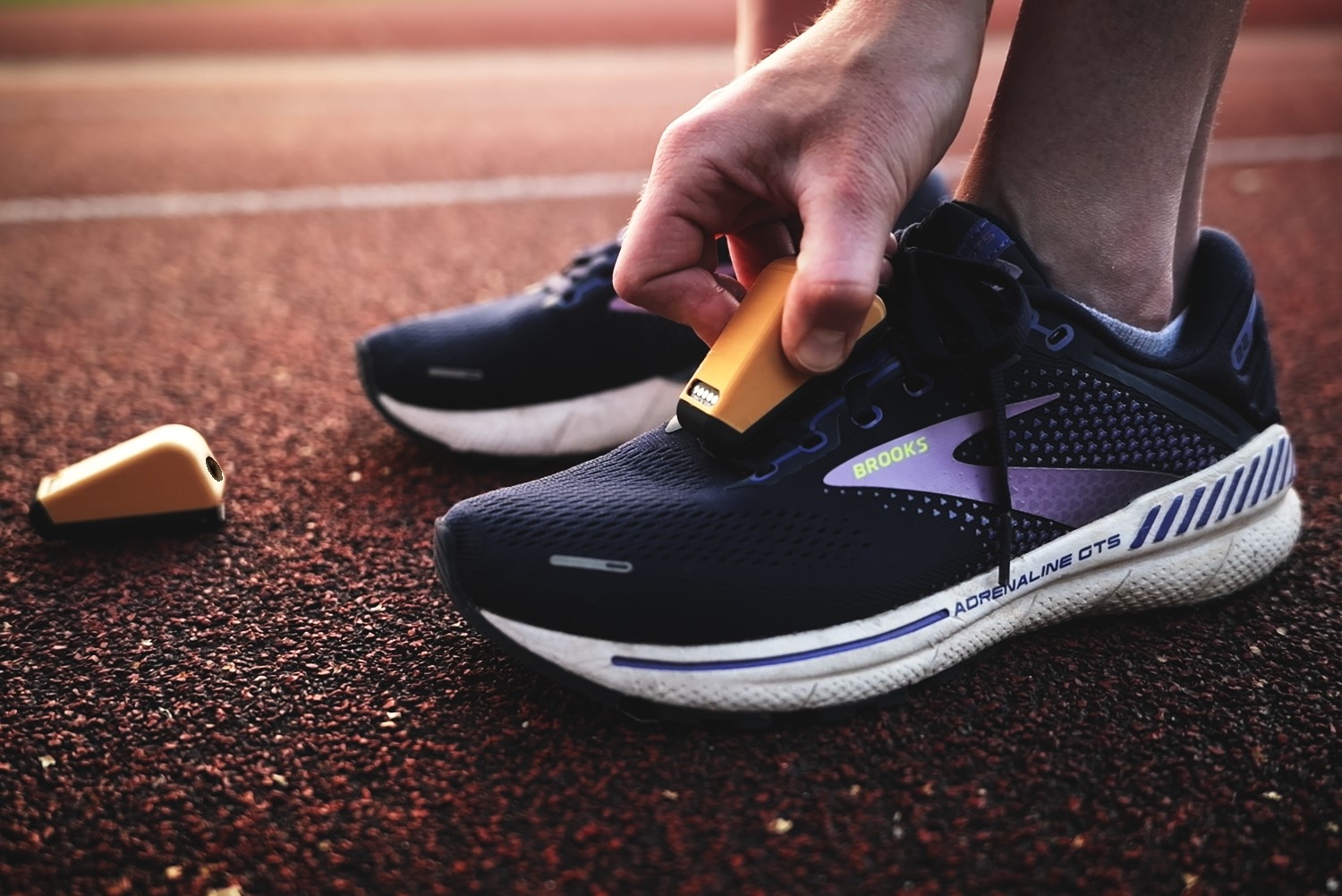 Compact performance-tracking sensor attached to a running shoe.
